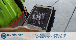 Close up of a Diversified Interiors employee looking at an iPad that’s using a laser scanner to plot location points of a construction site