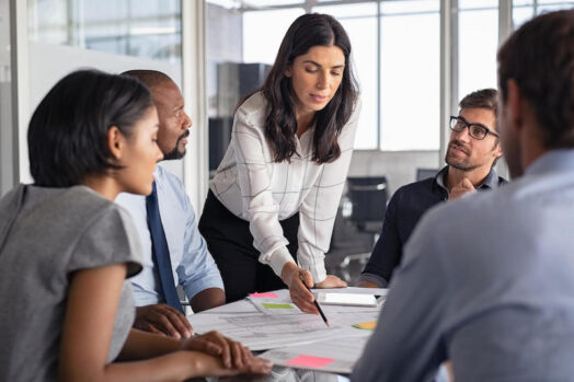 A project manager leads a meeting to discuss construction project planning and scheduling