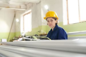 A woman performs a quality control inspection of construction material.